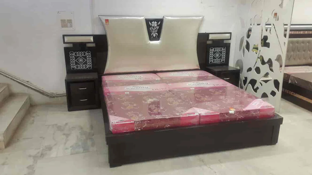 Bed with a light padded headboard and bedside units