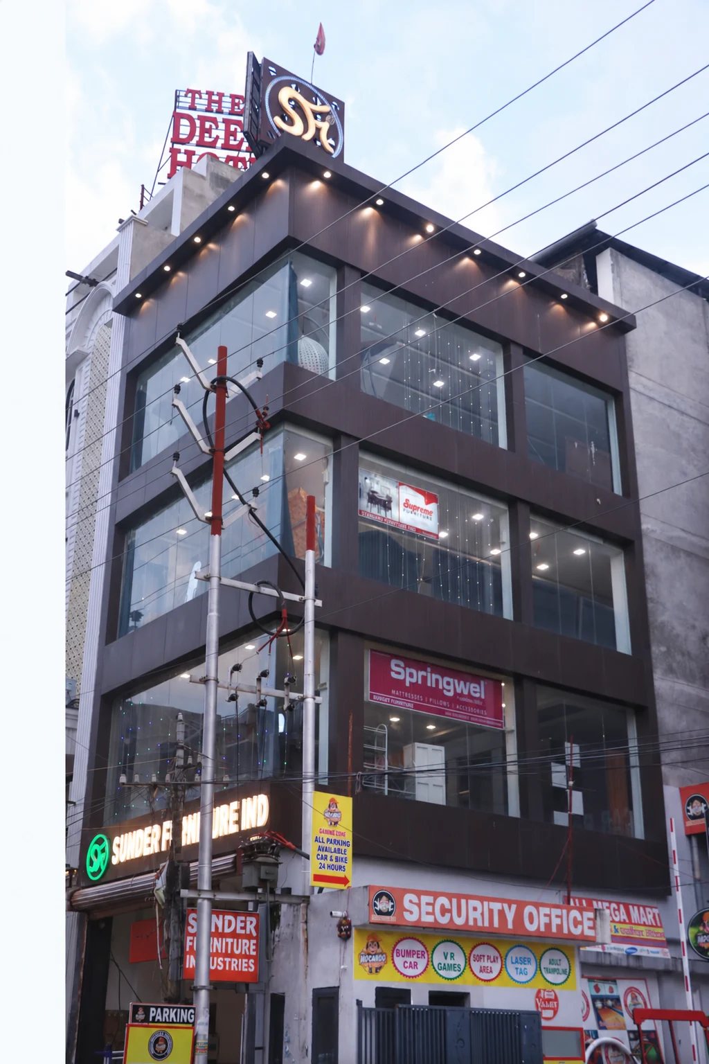 Side elevation of Sunder Furniture Industries in Kanpur, with its glass facade and rooftop SFi sign